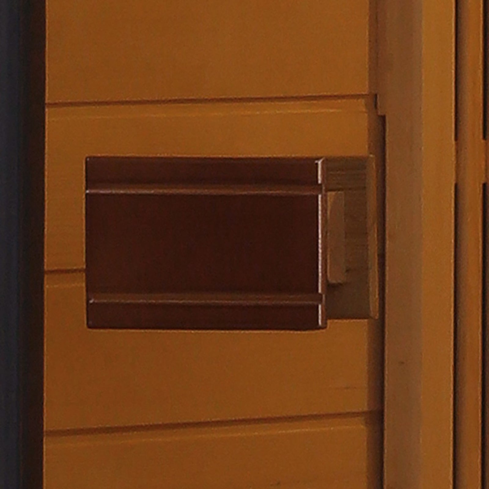 Tumma 2-Person Carbon Fibre Infrared Home Sauna with a rectangular Canadian hemlock construction, featuring a sleek door handle against a wood-paneled wall, designed for indoor relaxation and health benefits.