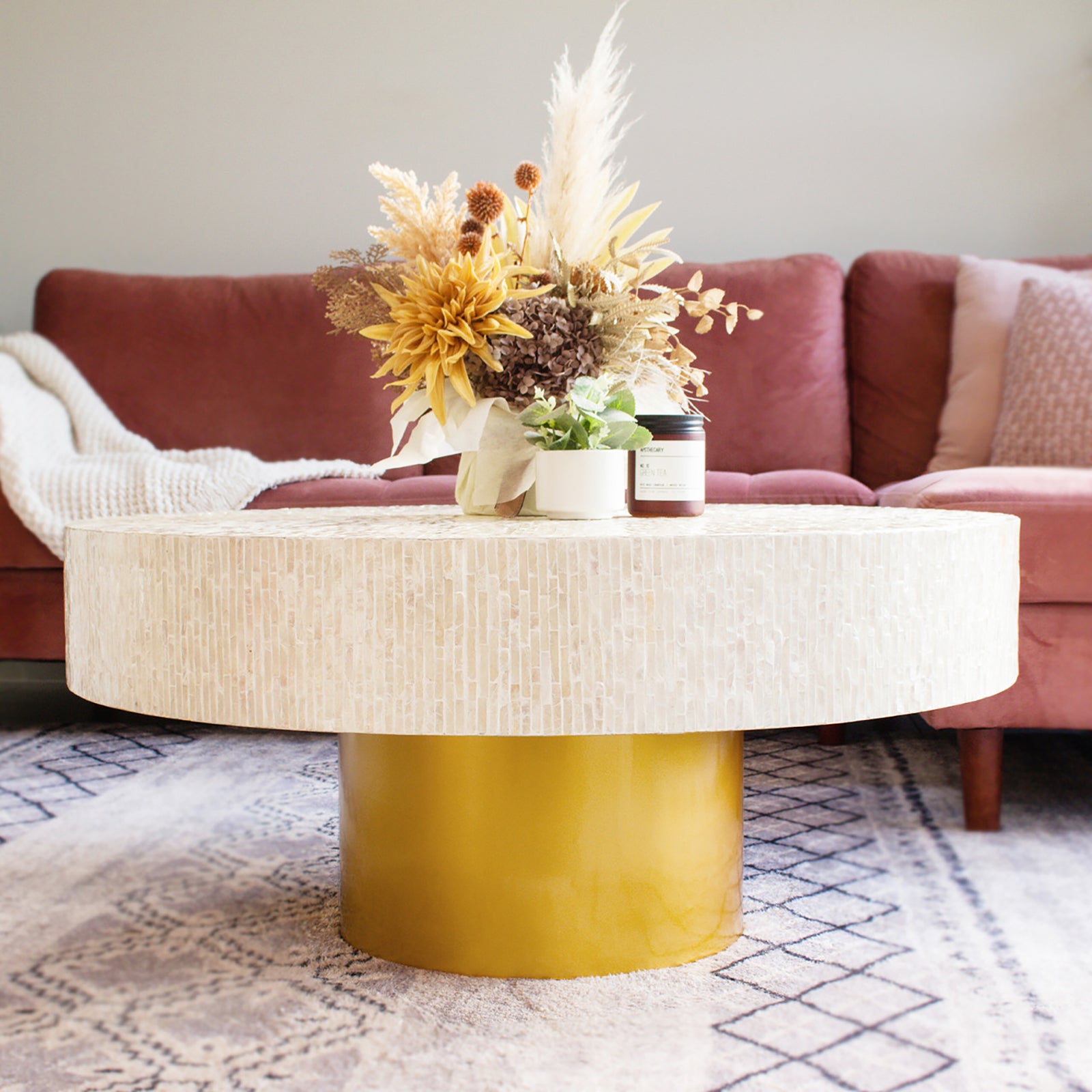 Abelene 91cm Pearl Inlay Coffee Table - Cream showcases a hand-crafted mother of pearl mosaic on a round top with a gold cylindrical pedestal, reflecting art deco elegance.