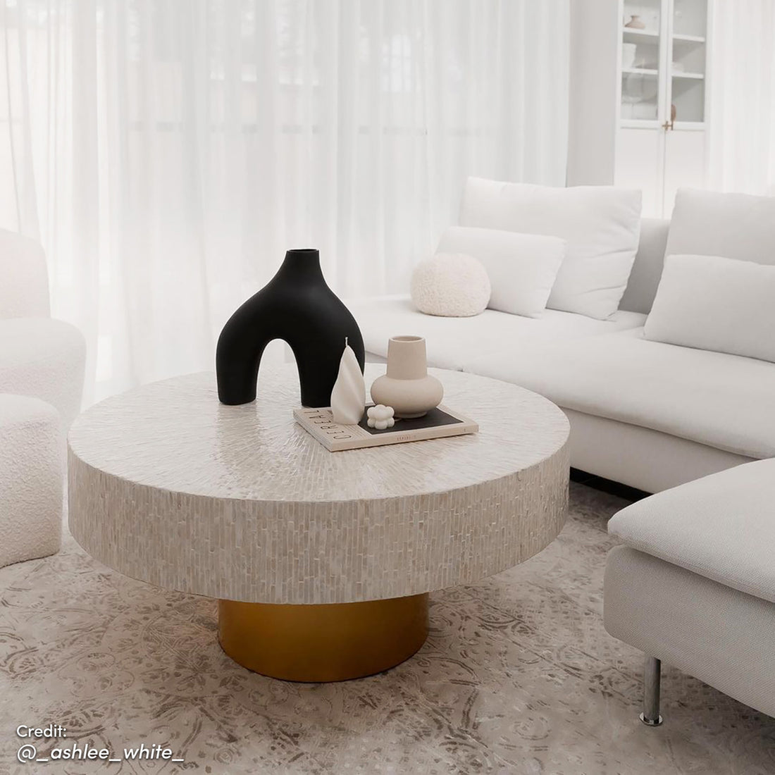 The Abelene 91cm Pearl Inlay Coffee Table features intricate mother of pearl mosaic on its surface with a cylindrical gold pedestal, creating a luxurious art deco focal point.