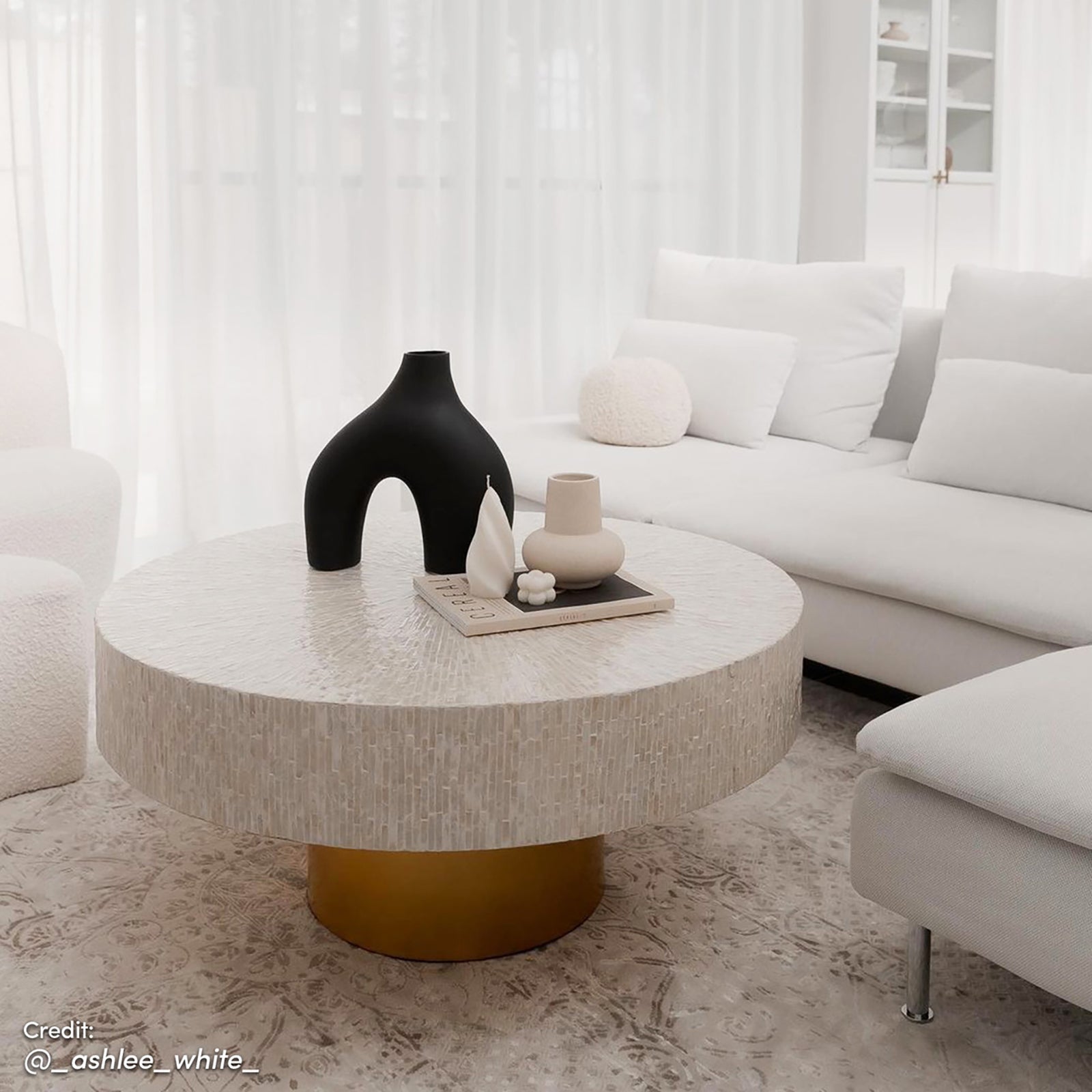 The Abelene 91cm Pearl Inlay Coffee Table features intricate mother of pearl mosaic on its surface with a cylindrical gold pedestal, creating a luxurious art deco focal point.
