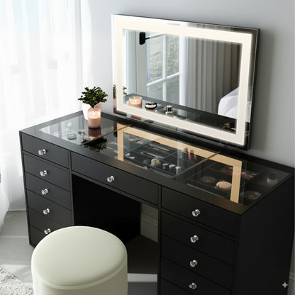 Adeline Makeup Vanity Table with LED Mirror in Black features a glossy black desk, LED-lit mirror, organized cosmetics, and a cream ottoman, creating a stylish, elegant dressing area.