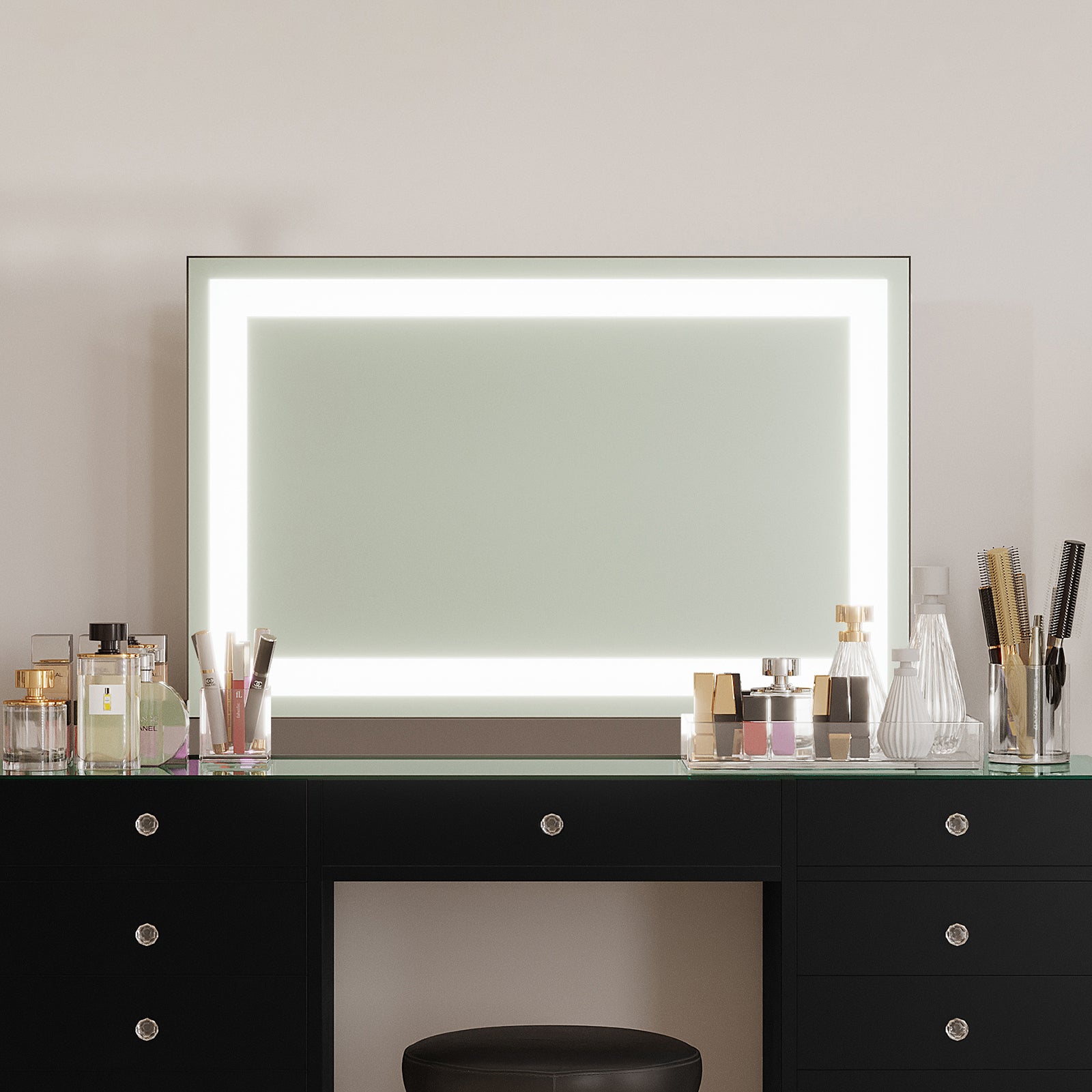 Adeline Wall Mount Touch Screen Mirror with LED Light in Black features a wide backlit frame, enhancing a modern vanity with a sleek black tabletop, crystal-knob drawers, and organized beauty trays.