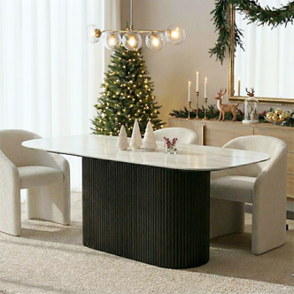 Aeris 180cm Marble Look Dining Table With Wood Base in Black, featuring a white oval sintered stone top on a dark fluted pedestal, set in a festive, minimalist holiday dining scene.