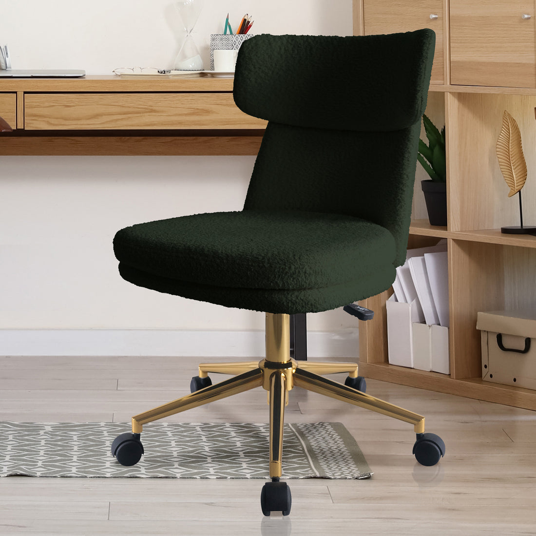Luxo Aerona High Back Boucle Office Chair in Dark Green, featuring plush upholstery, cushioned backrest, gold metal swivel base on caster wheels, situated before a light wood desk and shelving unit.