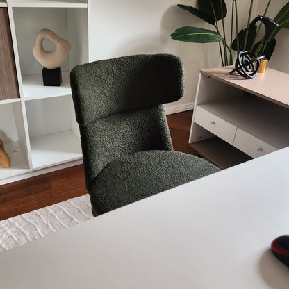Luxo Aerona High Back Boucle Office Chair in Dark Green, featuring plush boucle upholstery and ergonomic design, is centered in a stylish home office setting with modern decor elements.