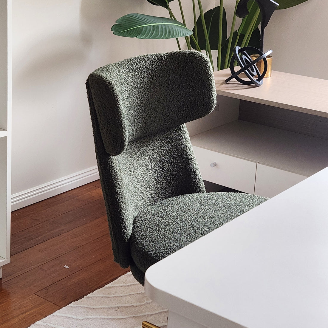 Luxo Aerona High Back Boucle Office Chair in Dark Green, featuring plush upholstery, high-back design, gold chrome base, tucked under a white tabletop in a modern home-office setting.