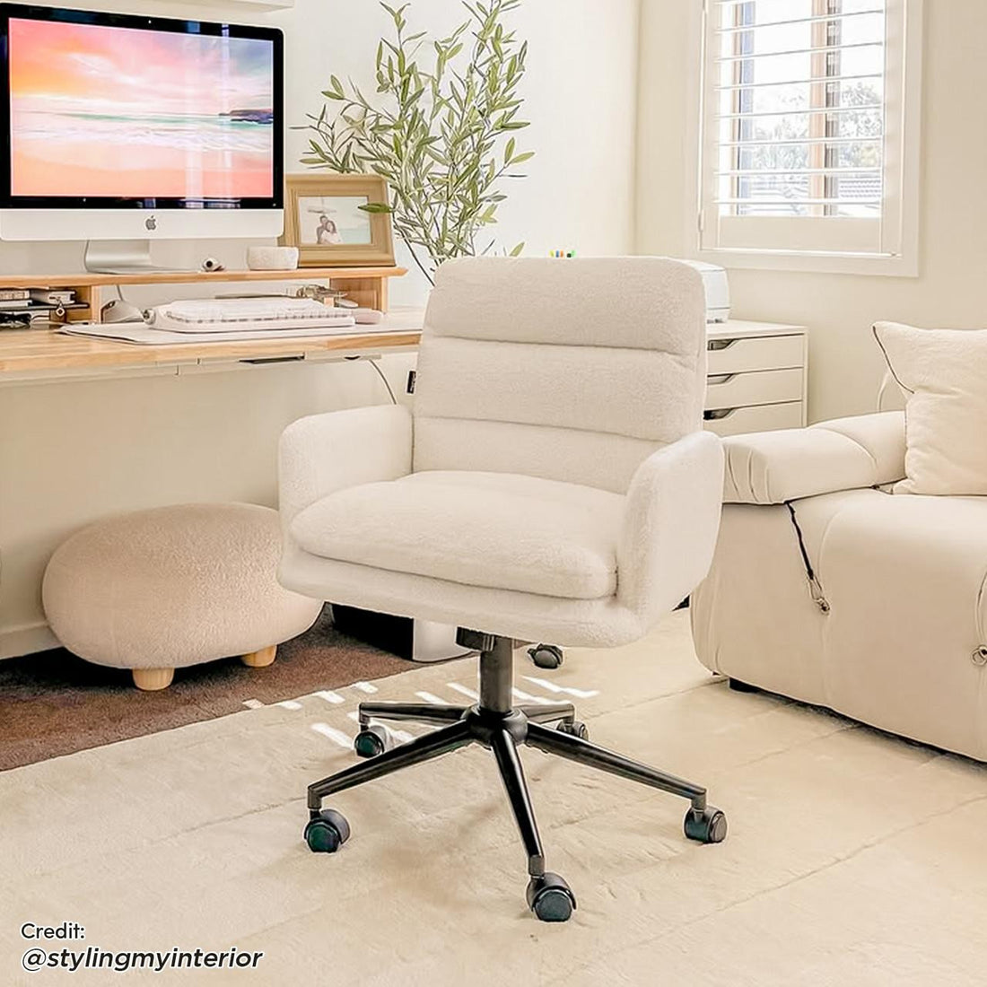 Luxo Aglaya Boucle Swivel Office Chair in Cream White, prominently featured with plush sherpa upholstery and black caster base, complements the modern home office setup with its elegant design.