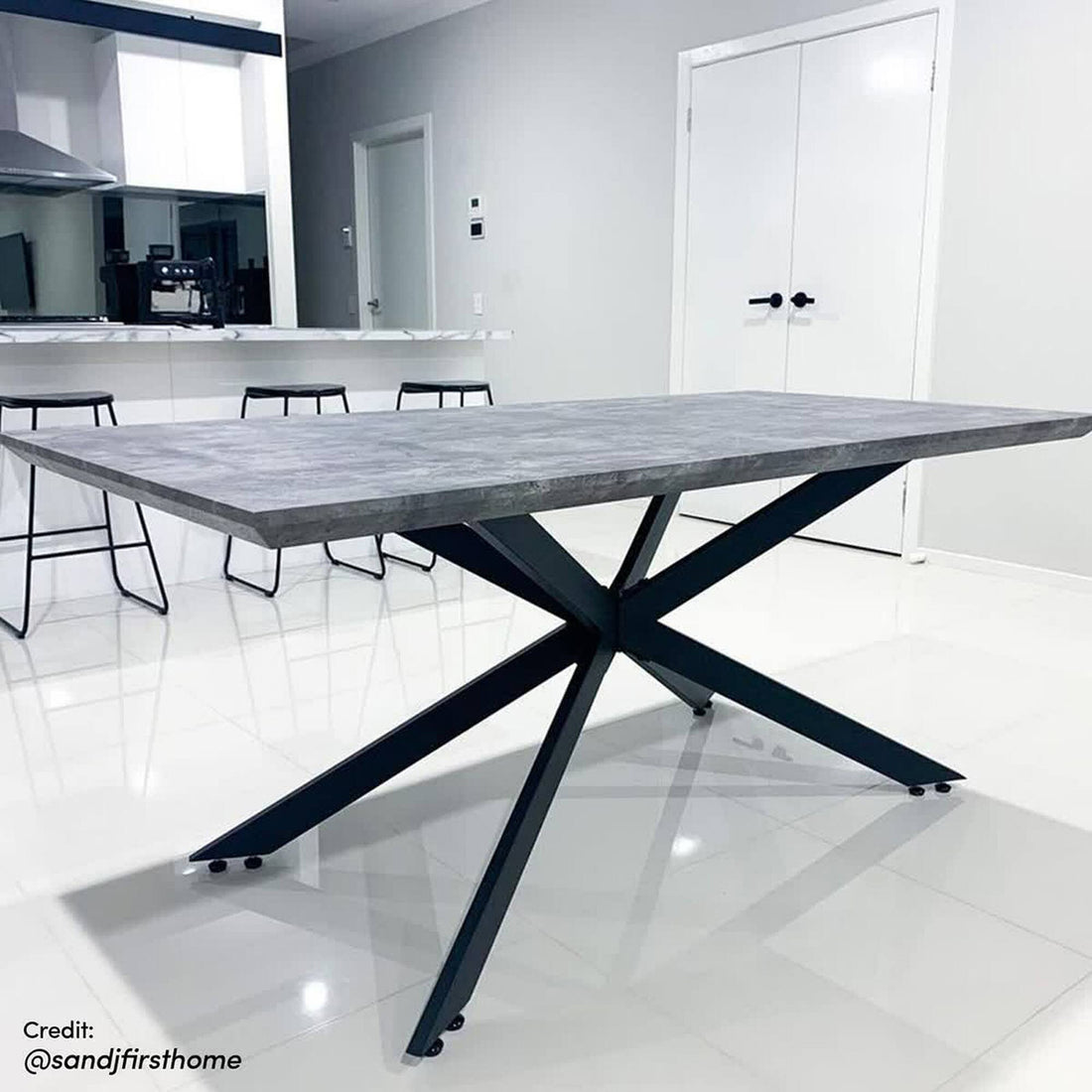 Alfred 180cm 6 Seater Pedestal Dining Table in Concrete, featuring a thick rectangular tabletop with a grey concrete-look finish and a black metal spider-style base, set in a modern white room.