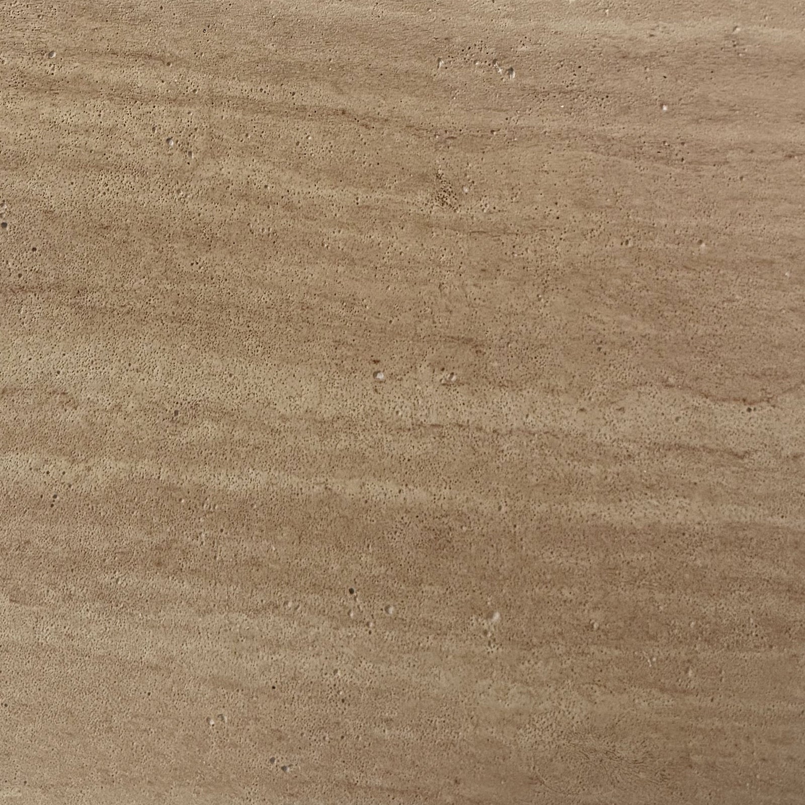 Close-up of Amarosa Curved Indoor/Outdoor Concrete Coffee Table Beige, showcasing its unique porous surface texture, resembling natural stone or wood grain, reflecting its robust and modern design for versatile indoor or outdoor use.