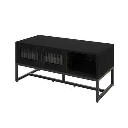 Ashley Coffee Table with Fluted Glass Door in Black features a sleek black metal frame, wood-grain top, ribbed glass sliding doors, and an open shelf, offering a modern, functional design.