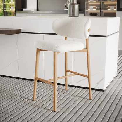 Audrey Curved Boucle Barstool Set of 2 in Cream White features an off-white boucle-upholstered, padded seat with natural wood legs and a minimalist marble counter backdrop, highlighting its elegant, modern design.
