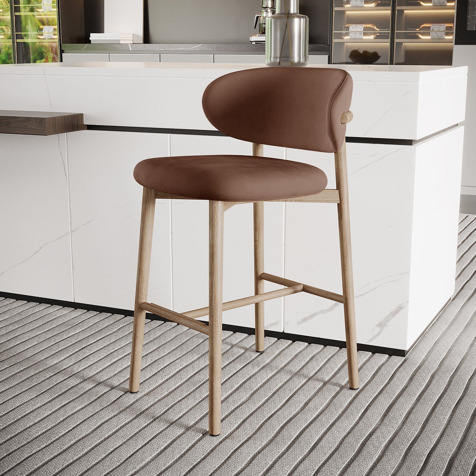Audrey Velvet Fabric Upholstered Barstool Mocha Mousse Set of 2 features a curved brown seat, light-wood frame, and four straight legs, positioned before a white kitchen island, highlighting modern elegance and functionality.