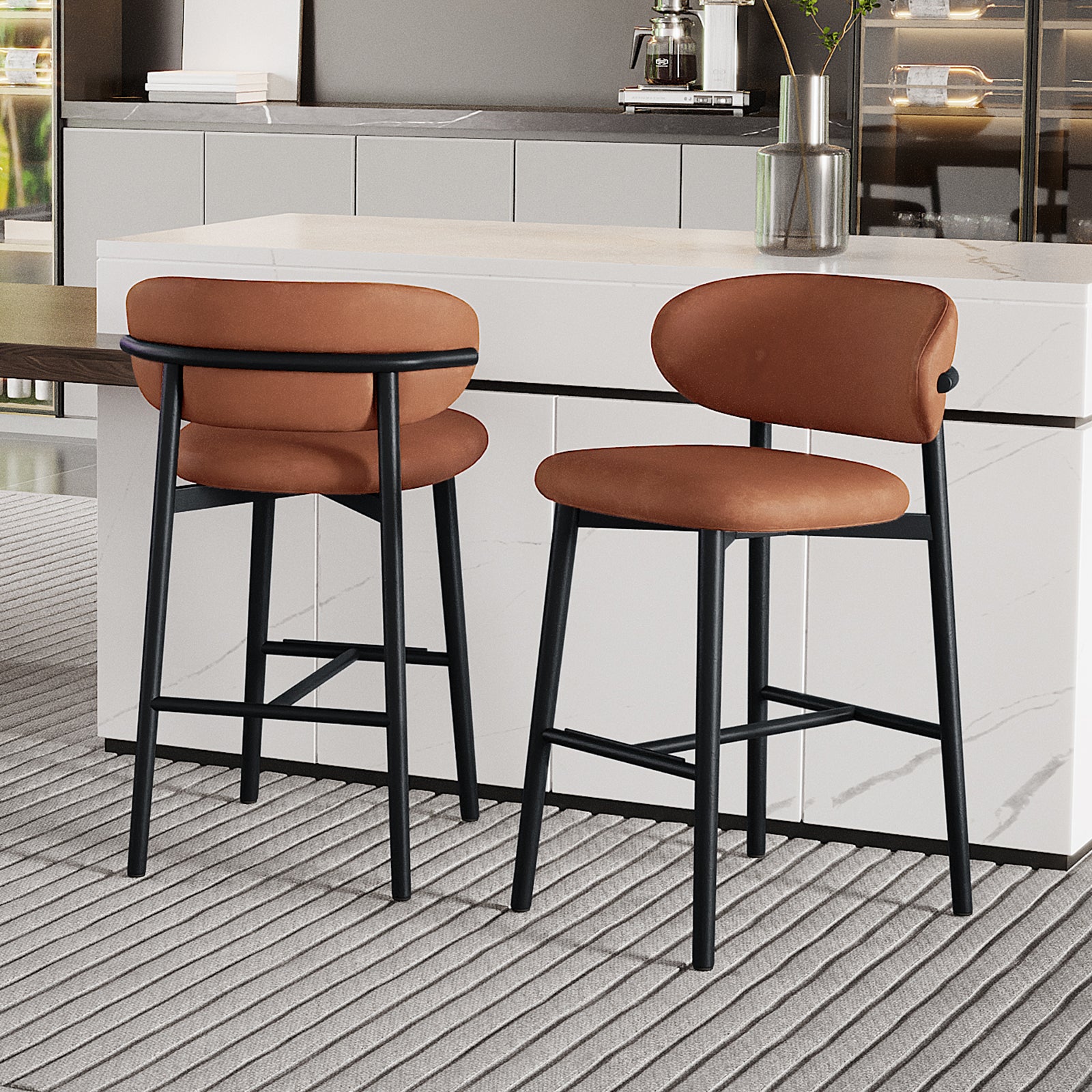 Audrey Curved PU Leather Barstool Set of 2 in Tan features warm brown, rounded seats and backrests on slim black metal legs, complemented by a modern kitchen setting with a marble-look island.