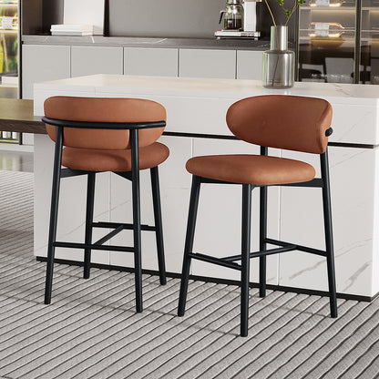Audrey Curved PU Leather Barstool Set of 2 in Tan features warm brown, rounded seats and backrests on slim black metal legs, complemented by a modern kitchen setting with a marble-look island.