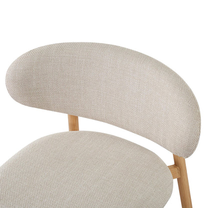 Audrey Curved Fabric Dining Chair Set of 2 in Beige, showcasing a close-up of the lightly textured fabric on the rounded seat and backrest, with a minimalist wooden frame in a natural finish.