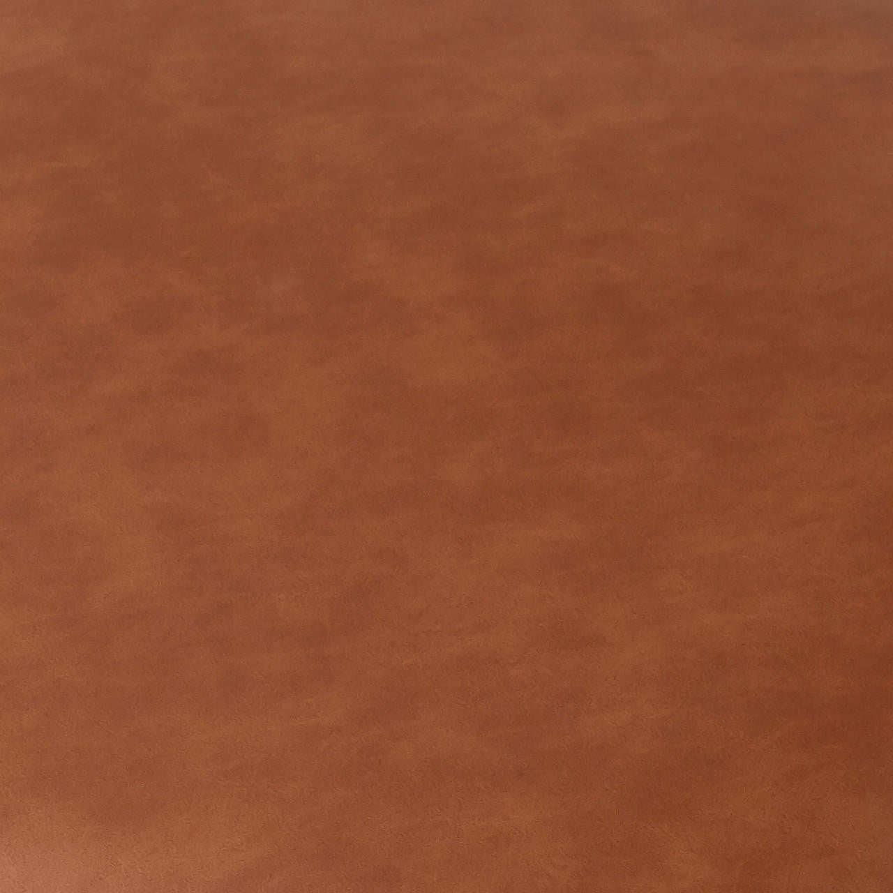 Close-up of the Audrey Curved Leather Dining Chair Set of 2 in Tan, showcasing a smooth, slightly mottled faux leather surface, highlighting the chair's elegant texture and sophisticated design.