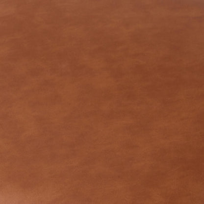 Close-up of the Audrey Curved Leather Dining Chair Set of 2 in Tan, showcasing a smooth, slightly mottled faux leather surface, highlighting the chair's elegant texture and sophisticated design.