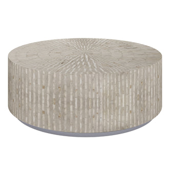 Baltoy 100cm Mother of Pearl Coffee Table in Striped Bone, featuring a round drum shape with textured surface and vertical striations, creating a floating appearance on a recessed plinth base.