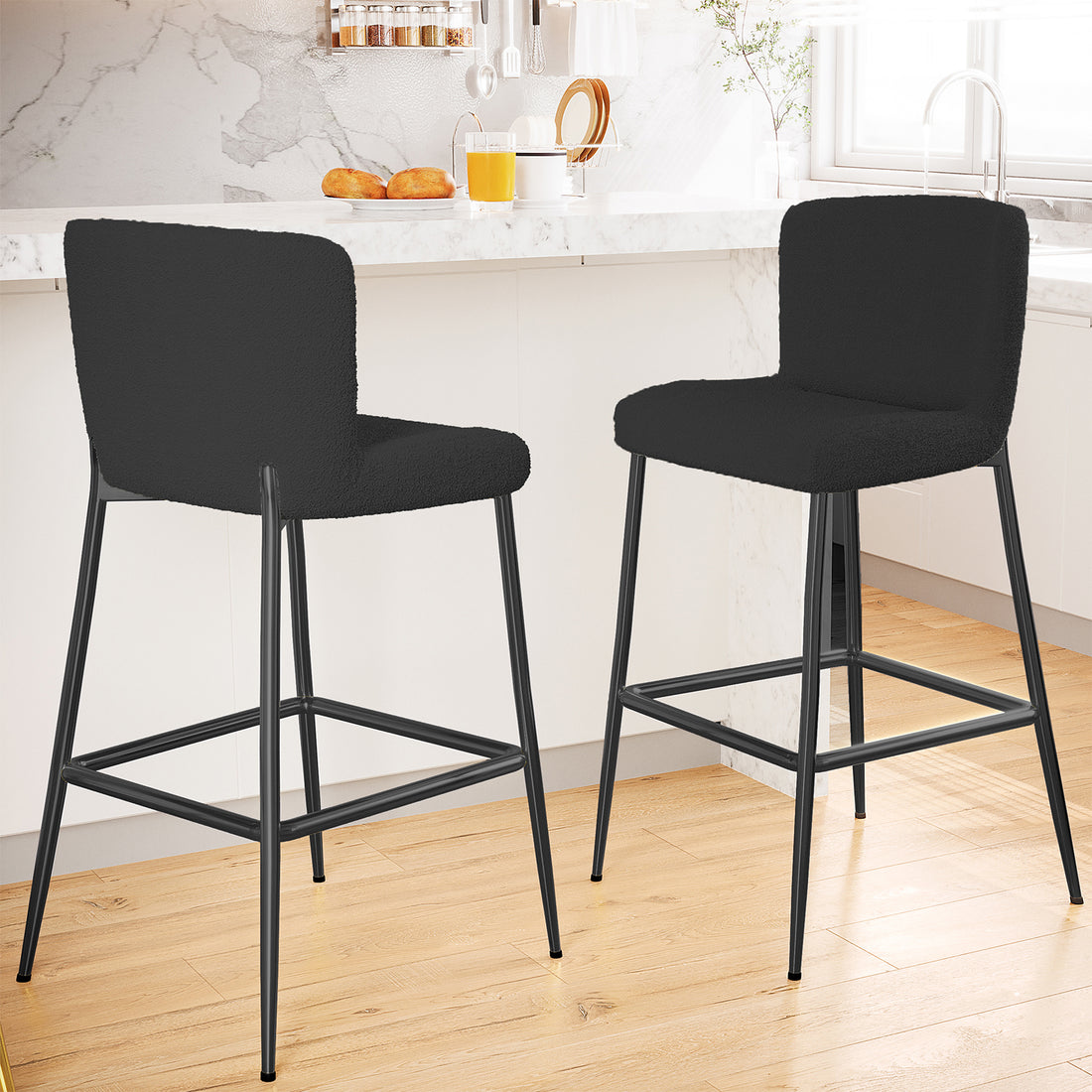 Bernie High Back Boucle Bar Stool Set of 2 in Black featuring plush, curved seats and backs, metal frames with footrests, placed in a modern kitchen with a white marble countertop island.