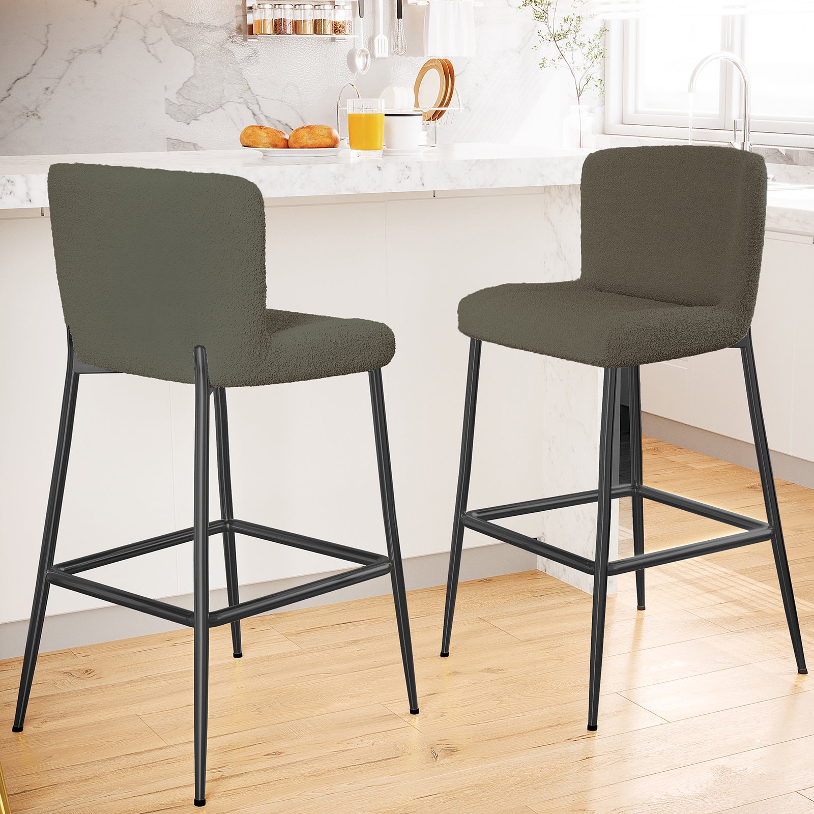 Bernie High Back Boucle Bar Stool Set of 2 in Green, featuring softly upholstered backs and seats, slender black metal legs, and a built-in footrest, complementing a modern kitchen island scene.