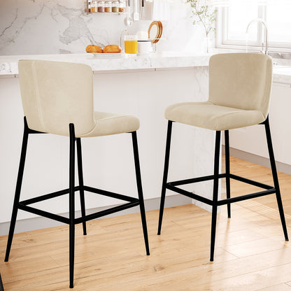 Bernie High Back Velvet Bar Stool Set of 2 in Oatmeal, featuring lightly upholstered beige seats, matte-black metal legs with footrests, positioned by a marble-topped island in a bright kitchen setting.
