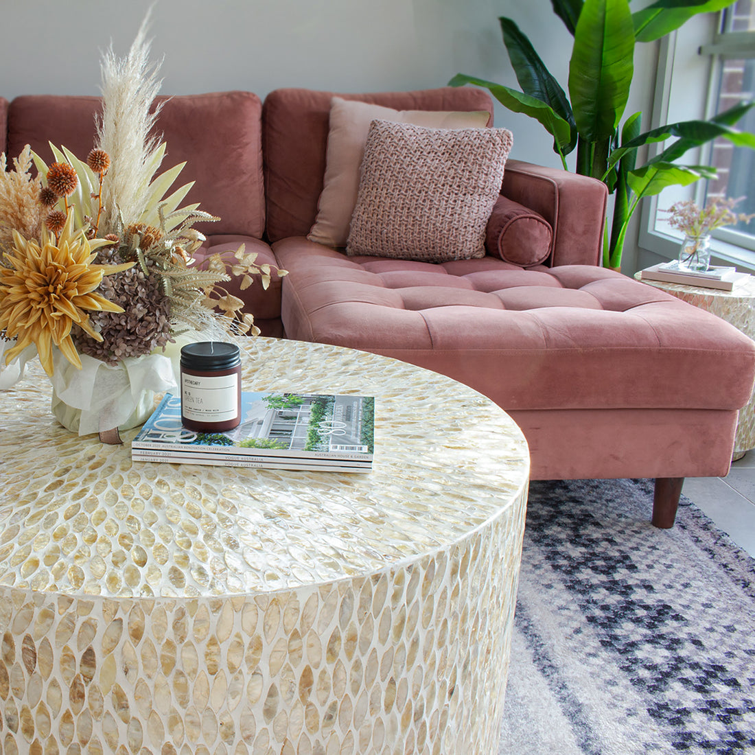 Bisera 91cm Mother of Pearl Inlay Coffee Table Beige, showcasing intricate mother-of-pearl mosaic detailing on its surface, set atop a stack of magazines, emphasizing its elegant craftsmanship and luxurious design.