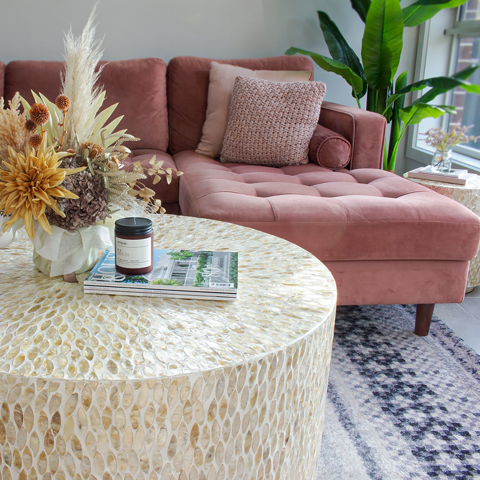 Bisera 91cm Mother of Pearl Inlay Coffee Table Beige, showcasing intricate mother-of-pearl mosaic detailing on its surface, set atop a stack of magazines, emphasizing its elegant craftsmanship and luxurious design.