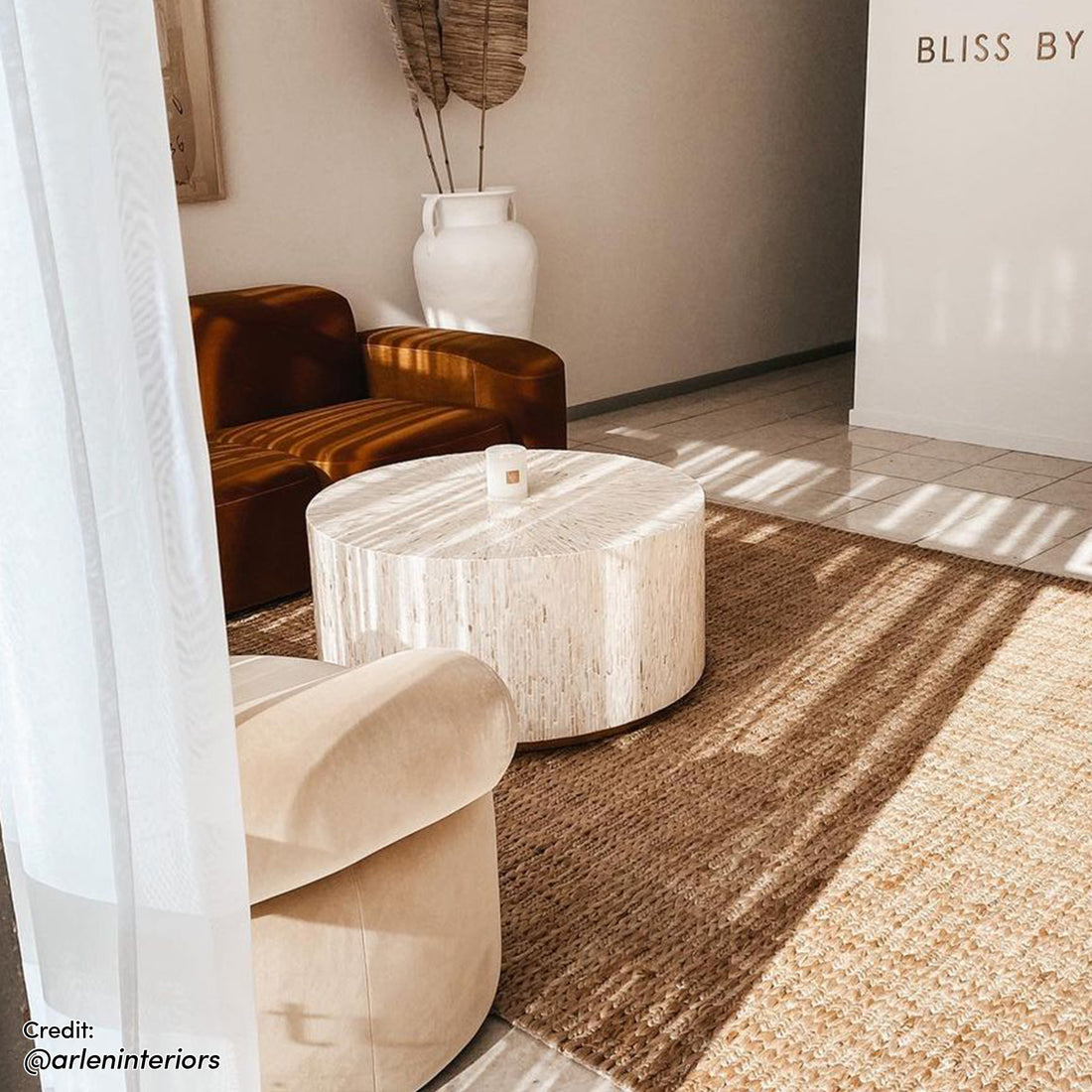 Bisera 91cm Mother of Pearl Inlay Coffee Table, showcasing a round design with exquisite handcrafted mother-of-pearl mosaic on its surface, topped with a candle, accompanied by a white vase.