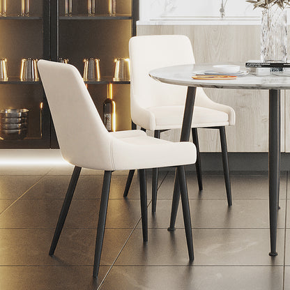 Blythe High Back Fabric Dining Chair Set of 2 in Cream White, featuring sleek black metal legs, upholstered seats around a marble-style table with decorative items in a modern dining setting.