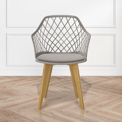 Caesar Beech Dining Chair Set of 4 in Grey, featuring a modern design with a crisscrossing open-lattice backrest, natural wood legs, and a slim cushion, on a herringbone wood floor.
