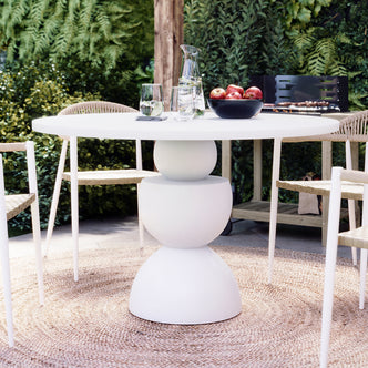 Carmen 120cm Indoor-Outdoor Concrete Dining Table - White, featuring a round top on a curvy artistic base, ideal for versatile dining settings.