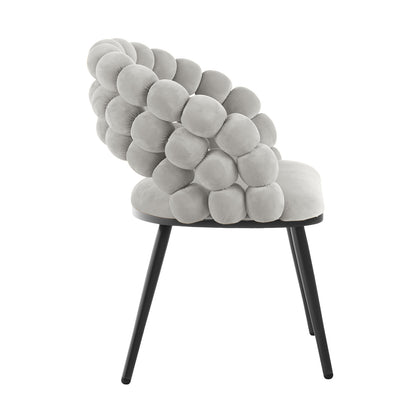 Claudine Velvet Curved Dining Chair Set of 2 in Warm Grey features a bubble-like backrest with tufted cushions atop slim black legs, offering a chic and comfortable seating solution.