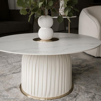 Combee 80cm Sintered Stone Coffee Table Cream White, showcasing a smooth sintered stone top with a unique shape, set against a minimalist backdrop with a white chair and a plant in a vase nearby.