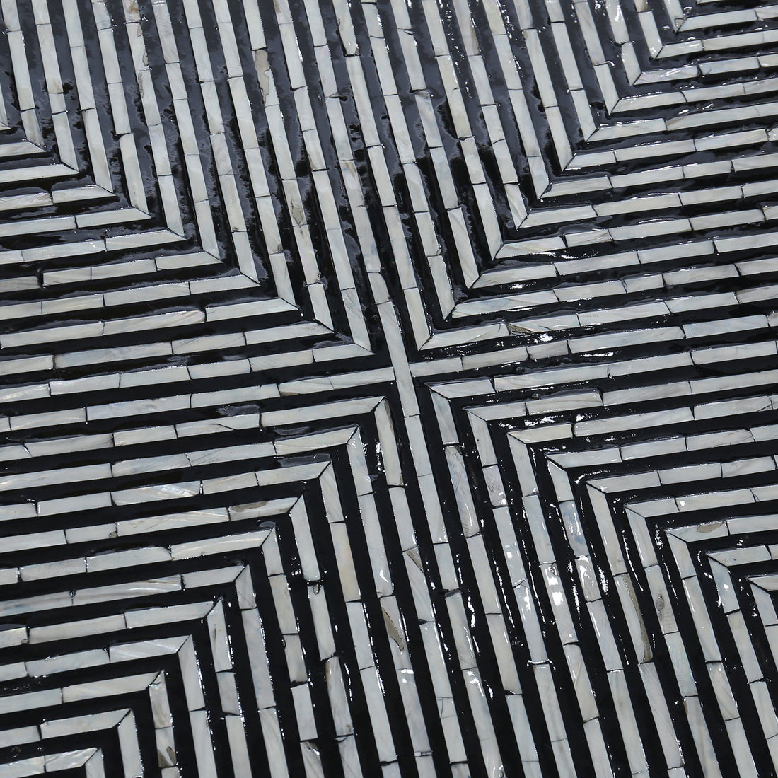Cradily Mother of Pearl Inlay Coffee Table features a geometric, labyrinth-like mosaic pattern with light tiles and dark grout, forming a square spiral design, showcasing its intricate craftsmanship and elegant centerpiece appeal.