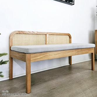 Dana 120cm Solid Oak Hardwood Bench - Natural with a backrest shown on a wooden surface, highlighting its solid oak construction, rattan backrest, and cushioned seat, ideal for home decor.