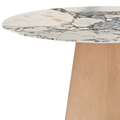 Dina 120cm Round Marble Dining Table in Blue Galaxy Natural features a white marble tabletop with grey and tan veining, supported by a single tapered wooden pedestal, offering a modern, elegant look.