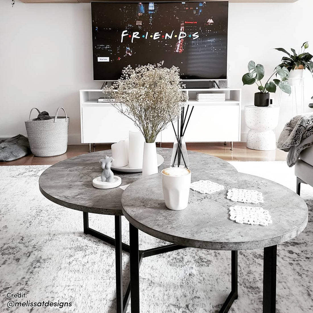 Earl Nesting Coffee Table Set of 2 - Concrete with sleek round tabletops and a sturdy metal frame, displayed on an indoor coffee table alongside a coffee cup, highlighting its modern, versatile design.