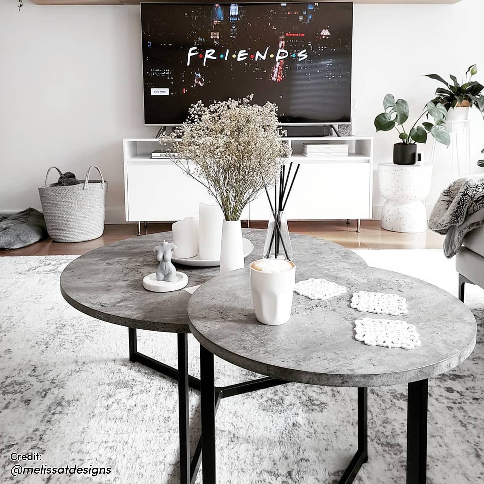 Earl Nesting Coffee Table Set of 2 - Concrete with sleek round tabletops and a sturdy metal frame, displayed on an indoor coffee table alongside a coffee cup, highlighting its modern, versatile design.