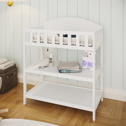 Elisabeth Solid Pine Baby Change Table with Storage in White features a padded top, middle tier with baby essentials, and an empty bottom tier. A woven basket with towels is beside it.
