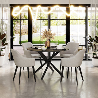 Ella Velvet Dining Chair Set of 2 in Beige around a dark-toned dining table, featuring plush beige velvet upholstery, black metal legs, and elegant design in a sunlit, contemporary dining nook.