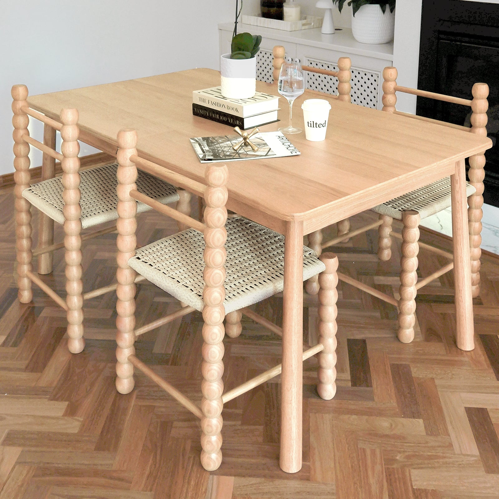 Em Solid Oak Dining Chair Set of 2 - Natural, featuring chunky bobbin-turned legs and woven seats, paired with a light-wood dining table on a herringbone parquet floor, enhancing modern and farmhouse interiors.