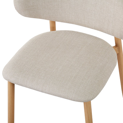 Close-up of an Audrey dining chair from the Enid Round Table with 4 Audrey Dining Chair Set - Beige, showcasing wicker armrest, linen fabric upholstery, foam padding, and sleek wood-feel metal legs.