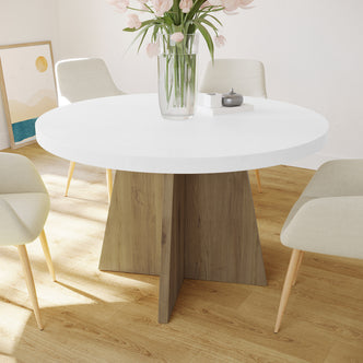Enid 120cm 4 Seater Round Dining Table in White, featuring a sleek white tabletop and intersecting wooden base, surrounded by four cream chairs with wooden legs, adorned with a vase of pink tulips.