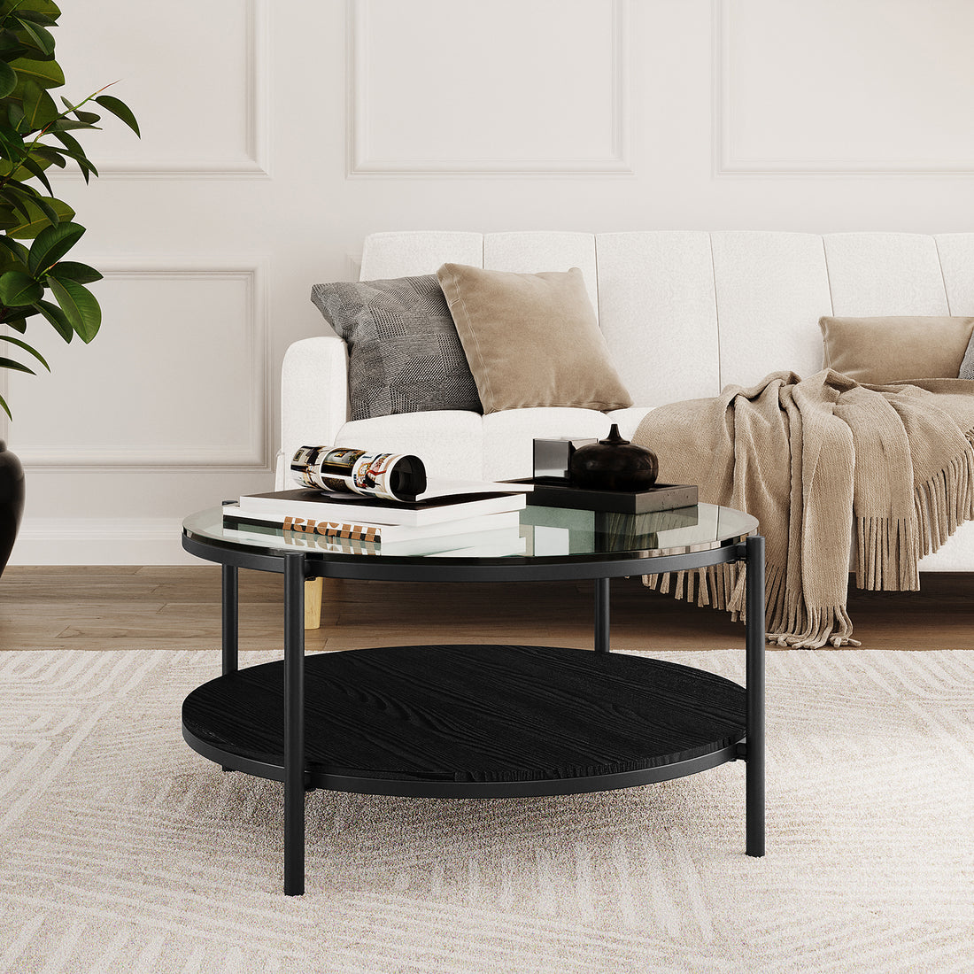 Frances 80cm Round Tempered Glass Coffee Table in Black features a sleek glass top, black metal frame, and a wood lower shelf, elegantly styled with books and a decorative object.