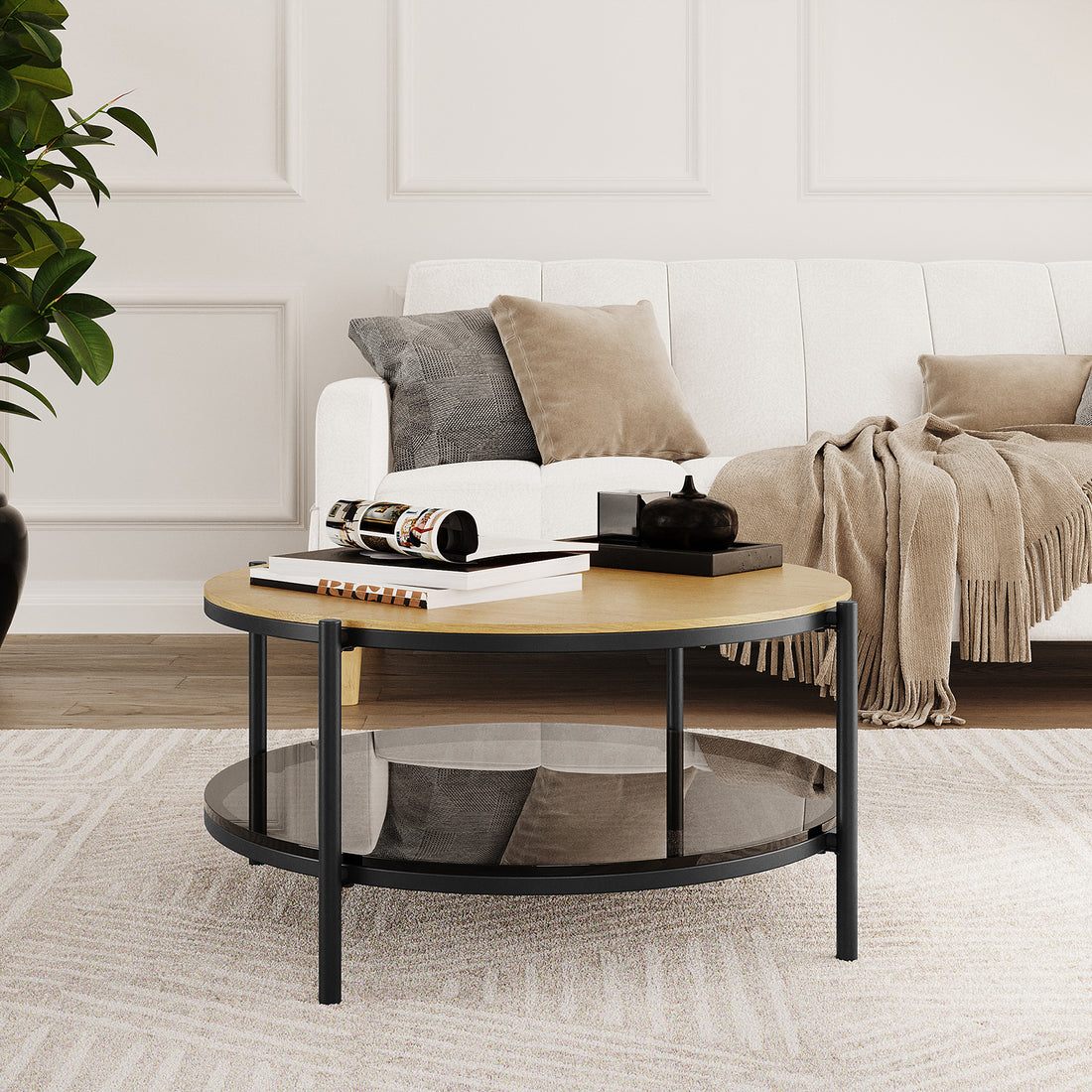 Frances 80cm Round Tempered Glass Coffee Table in Natural with light wood top, smoked-glass shelf, black metal legs; features books, magazine, black tray with teapot on top, enhancing sophisticated living area.