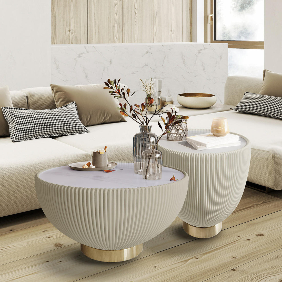 Glalie Sintered Stone Coffee Table Set in Cream White, featuring round, fluted tables with brass-tone bases, adorned with a small tray, vases, a geometric ornament, books, and a lit candle.