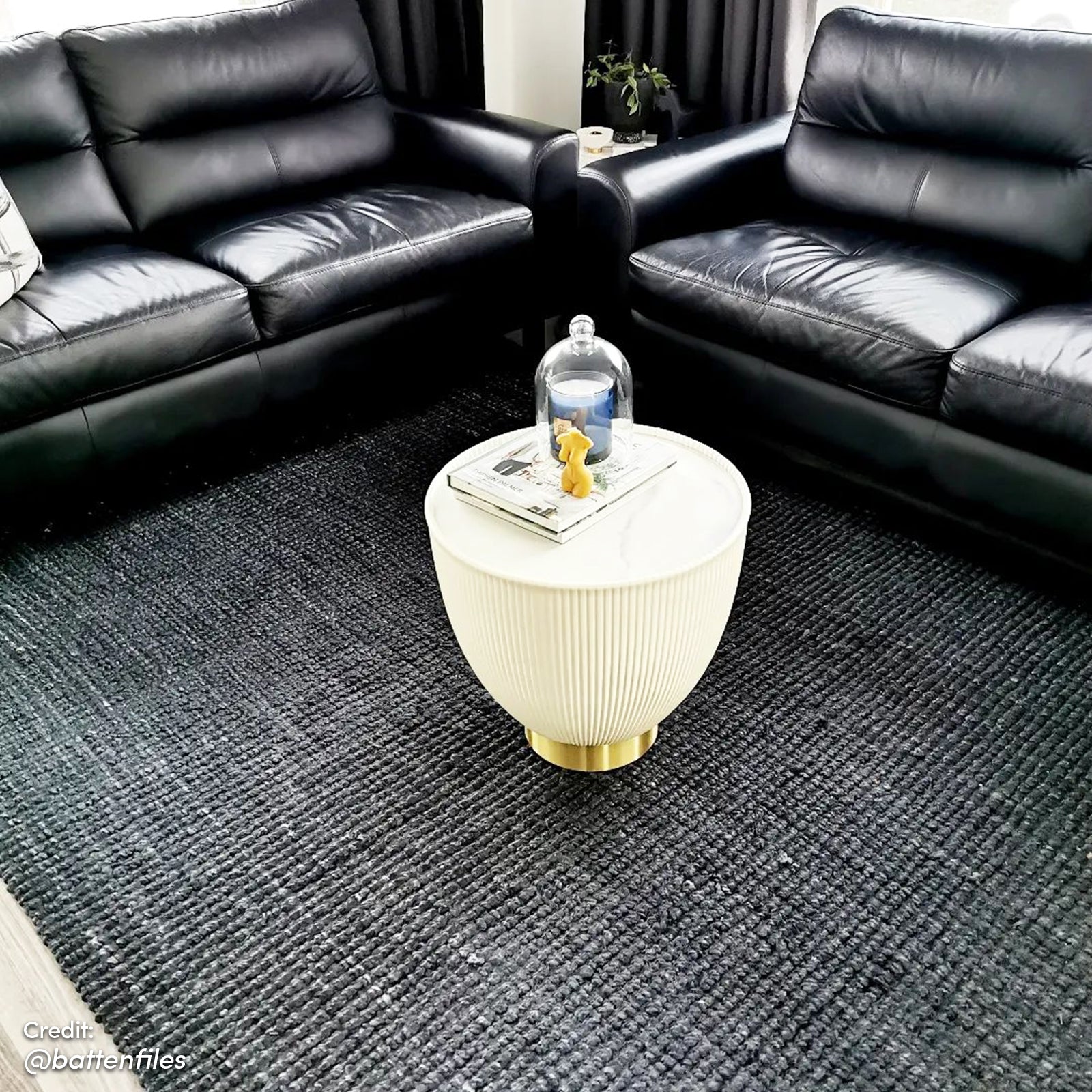 Glalie 47cm Sintered Stone Coffee Table in Cream White, featuring a pleated side design with a brass-tone base, topped with books, a yellow bear-shaped candle, and a glass cloche.