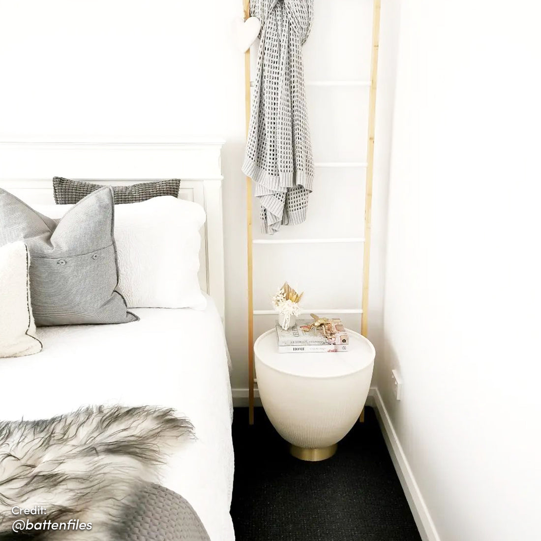 Glalie 47cm Sintered Stone Coffee Table in Cream White, showcased as a small round side table with books, a vase, and decorative items, enhancing the minimalist bedroom corner.