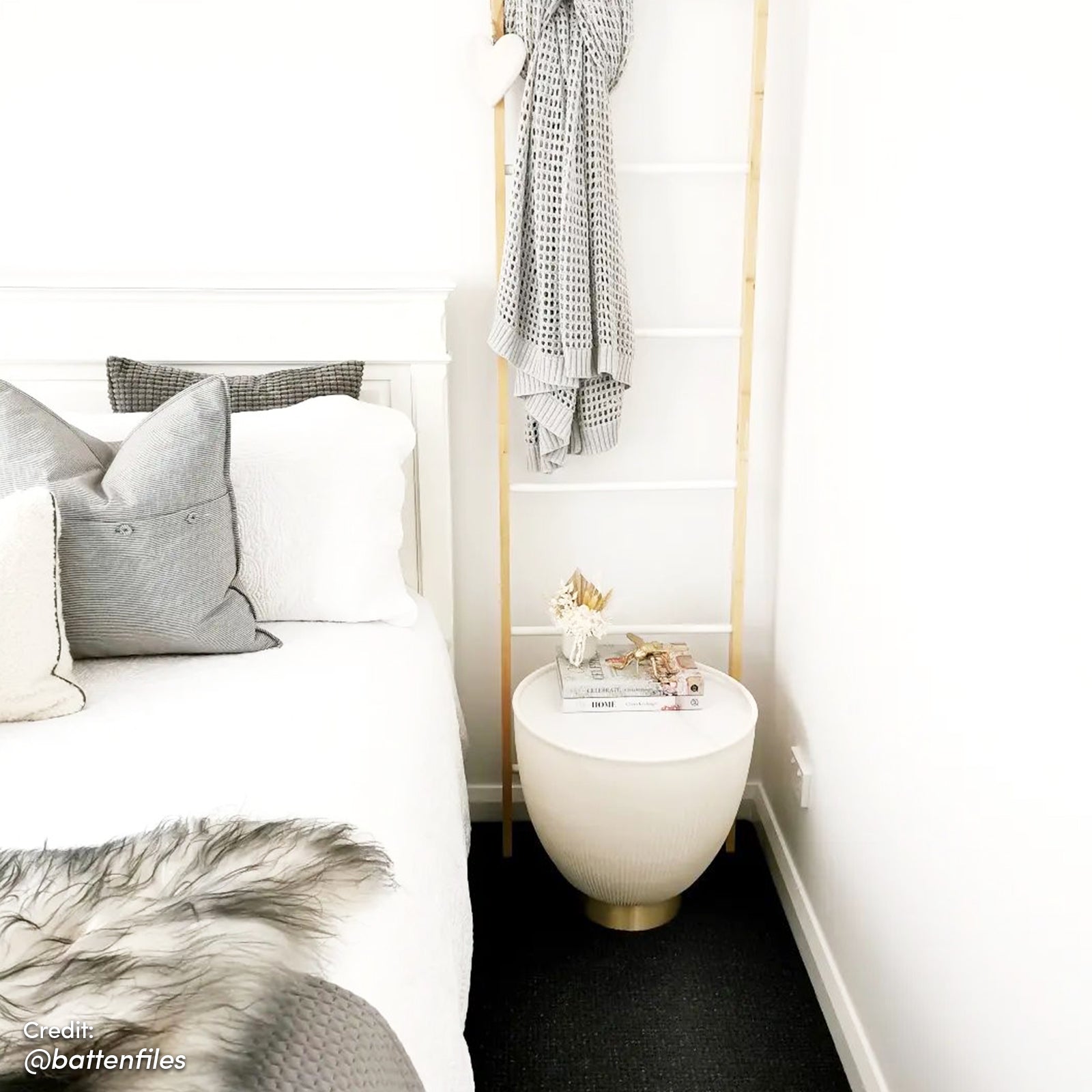 Glalie 47cm Sintered Stone Coffee Table in Cream White, showcased as a small round side table with books, a vase, and decorative items, enhancing the minimalist bedroom corner.