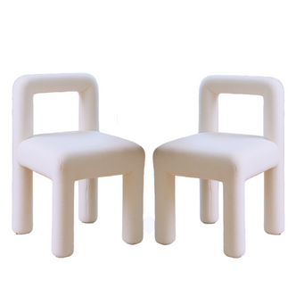 Hazel Boucle Dining Chair Set of 2 in Cream White features modern square open-frame backrests, thick cushioned seats, and cylindrical legs, all upholstered in textured off-white boucle fabric.
